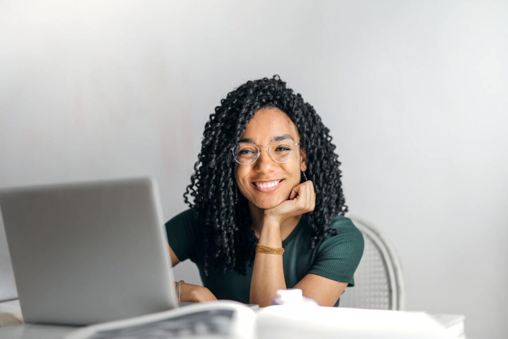 Freelance Writing Tips to Make Your First $100 1 Happy ethnic woman sitting at table with laptop