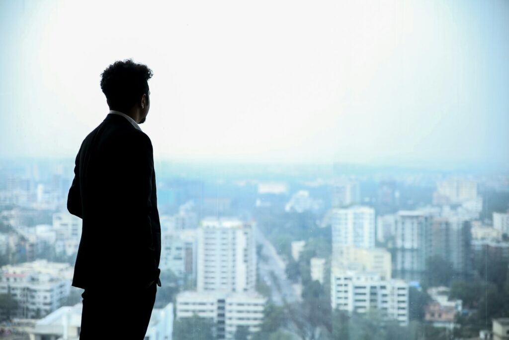 Online Fitness Coaching: Earn by Helping Others Get Fit 1 man in black suit standing on top of building looking at city buildings during daytime